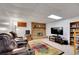 Finished basement area featuring a brick fireplace, comfortable seating, and entertainment setup at 8040 W 78Th Way, Arvada, CO 80005