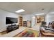 Finished basement area with entertainment setup, bookcases, and an adjacent seating area at 8040 W 78Th Way, Arvada, CO 80005