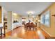 Bright, open dining area with wood floors, plantation shutters, and adjoining kitchen featuring tile backsplash at 8040 W 78Th Way, Arvada, CO 80005