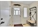 Bright foyer with white door, bench and coat rack, tile floor and a window at 8040 W 78Th Way, Arvada, CO 80005