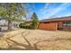 Spacious front yard, featuring a neatly kept lawn, shrubbery, and brick exterior of the home at 8040 W 78Th Way, Arvada, CO 80005