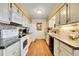 Functional kitchen with bright cabinets, modern appliances, tile backsplash and wood-look floor at 8040 W 78Th Way, Arvada, CO 80005