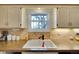 Kitchen sink with black faucet, mosaic backsplash, and natural light at 8040 W 78Th Way, Arvada, CO 80005