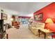 Open-concept living space with a red accent wall and dining area, perfect for gatherings at 8040 W 78Th Way, Arvada, CO 80005