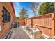 Relaxing patio area includes wood fence, chairs, brickwork, and a storage box to complete the design at 8040 W 78Th Way, Arvada, CO 80005