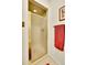 Tile shower with glass door and gold trim. Includes red towel on wall at 8040 W 78Th Way, Arvada, CO 80005