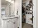 Bathroom featuring granite countertops, white cabinetry, and access to a custom walk-in closet with shelving at 10080 E 160Th Pl, Brighton, CO 80602