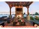 Inviting backyard patio with an outdoor fireplace, TV and cozy seating under string lights at 10080 E 160Th Pl, Brighton, CO 80602