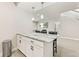 Modern kitchenette featuring white cabinetry, granite countertops, a breakfast bar, and pendant lighting at 10080 E 160Th Pl, Brighton, CO 80602