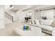 Spacious living area with comfortable seating, staircase access, and an open view of the kitchenette and wet bar at 10080 E 160Th Pl, Brighton, CO 80602