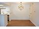 Living room with wood flooring, a modern light fixture, and open access to the kitchen at 922 S Walden St # 101, Aurora, CO 80017