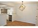 Living room with wood flooring, a modern light fixture, and open access to the kitchen at 922 S Walden St # 101, Aurora, CO 80017