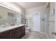 Bright bathroom with double sinks, a large mirror, and a walk-in shower at 8707 E Florida Ave # 410, Denver, CO 80247