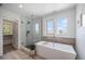 Bright bathroom featuring a glass-enclosed shower, soaking tub, and modern fixtures at 4180 Ames St, Denver, CO 80212