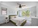 Well-lit bedroom featuring neutral decor, ceiling fan, and large windows with green outdoor views at 4180 Ames St, Denver, CO 80212