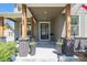 Inviting front porch with rustic wood pillars and black brick accents at 4180 Ames St, Denver, CO 80212