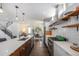 Bright kitchen with stainless steel appliances, floating shelves, and an island with seating at 4180 Ames St, Denver, CO 80212