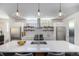 Bright kitchen featuring a large island with pendant lights, stainless steel appliances, and a white backsplash at 4180 Ames St, Denver, CO 80212