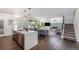 Open-concept kitchen with island seating area flowing into living room and staircase at 4180 Ames St, Denver, CO 80212