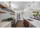Bright kitchen with stainless steel appliances, floating shelves and dark hardwood floors at 4180 Ames St, Denver, CO 80212