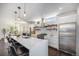 Modern kitchen featuring a large island, stainless steel appliances, and floating shelves at 4180 Ames St, Denver, CO 80212