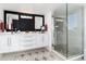 Modern bathroom featuring a double vanity, elegant mirrors, and a glass-enclosed shower at 9742 Fairwood St, Littleton, CO 80125