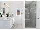 Modern bathroom featuring a glass shower with tiled walls and floors, and white vanity with a sleek mirror at 9742 Fairwood St, Littleton, CO 80125