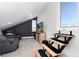 A cozy bonus room with theater seating, a modern media center, and unique staircase leading to a rooftop deck at 9742 Fairwood St, Littleton, CO 80125