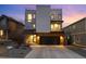 Modern three-story home with a rooftop deck and stone and white stucco facade with a two car garage at 9742 Fairwood St, Littleton, CO 80125