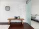 Hallway with dark floors, a wood bench, stylish decor and a glimpse into a bedroom through a frosted glass door at 9742 Fairwood St, Littleton, CO 80125