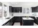 This modern kitchen features sleek black cabinets, white countertops, and ample natural light from large windows at 9742 Fairwood St, Littleton, CO 80125