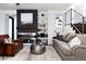 Open-concept living room with modern fireplace, floating shelves and a staircase with stainless steel banisters at 9742 Fairwood St, Littleton, CO 80125