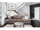 Open-concept living room with modern couch, a view into the staircase with stainless steel banisters at 9742 Fairwood St, Littleton, CO 80125