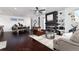 Open-concept living room with hardwood floors, modern fireplace, floating shelves and a view into the dining room at 9742 Fairwood St, Littleton, CO 80125