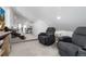 Bright loft with two gray recliners, a nearby desk, and a small staircase leading to a separate seating area at 9742 Fairwood St, Littleton, CO 80125