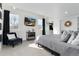 The main bedroom features ample natural light, a mounted television, and a view into an ensuite bathroom at 9742 Fairwood St, Littleton, CO 80125