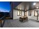 An exterior view shows a covered dining area with a wood table, seating and access to the home's interior at 9742 Fairwood St, Littleton, CO 80125