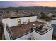 An aerial view showcases a rooftop deck complete with a fire pit, lounge area, and stunning mountain views at 9742 Fairwood St, Littleton, CO 80125