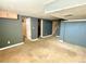 Open basement with neutral carpet, gray walls, and access to multiple rooms at 2561 W Dartmouth Ave, Denver, CO 80236