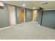 Open basement with new carpet, neutral paint, and multiple access points at 2561 W Dartmouth Ave, Denver, CO 80236