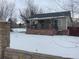 House exterior with snowy front yard and stone pillars at 2561 W Dartmouth Ave, Denver, CO 80236