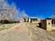 A home featuring a long dirt driveway, a quaint porch, and mature trees at 2561 W Dartmouth Ave, Denver, CO 80236