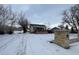 Winter view of charming home with snow-covered yard, featuring a stone mailbox and inviting curb appeal at 2561 W Dartmouth Ave, Denver, CO 80236