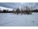 Snow-covered vacant lot with sparse vegetation at 2561 W Dartmouth Ave, Denver, CO 80236