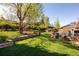 A backyard has a stone terraced wall and a large lawn with an outdoor sofa at 26 Morningside Dr, Wheat Ridge, CO 80215