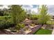 The backyard has a stone terraced retaining wall with flowers and an outdoor seating area at 26 Morningside Dr, Wheat Ridge, CO 80215