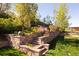 A stone terraced retaining wall leads to the upper portion of the yard, filled with flowers at 26 Morningside Dr, Wheat Ridge, CO 80215
