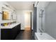 Modern bathroom with dual sinks, dark cabinetry, and a shower-tub combination at 26 Morningside Dr, Wheat Ridge, CO 80215
