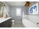 Modern bathroom features a freestanding tub, unique light fixture, graphic flooring, and vanity at 26 Morningside Dr, Wheat Ridge, CO 80215