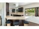 A modern kitchen with dark wood cabinets, a breakfast bar, and a pass-through window to the backyard at 26 Morningside Dr, Wheat Ridge, CO 80215